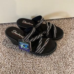 Black wedge sandals with silver accents. Brand new. Never been worn.